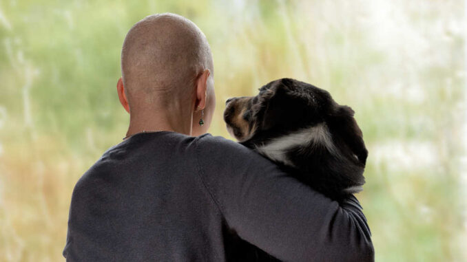 dog with cancer next to owner