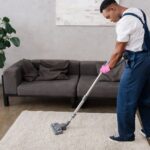 man vacuuming rug in house