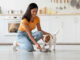 woman feeding her dog with a bowl in the kitchen