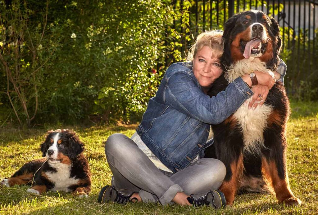 Owner with senior dog and puppy